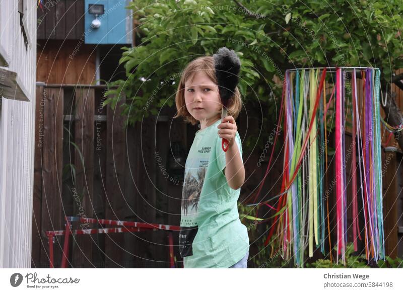 Girl looks grimly into the camera with a hand broom hand brush sweep Feminine Ferocious Evil Looking Human being Threat Grimace Looking into the camera out