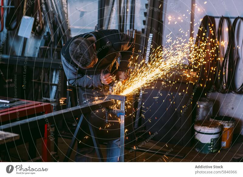 Blacksmith working with angle grinder in workshop blacksmith male metal sparks grinding occupation industrial craftsmanship manufacturing artisan skill