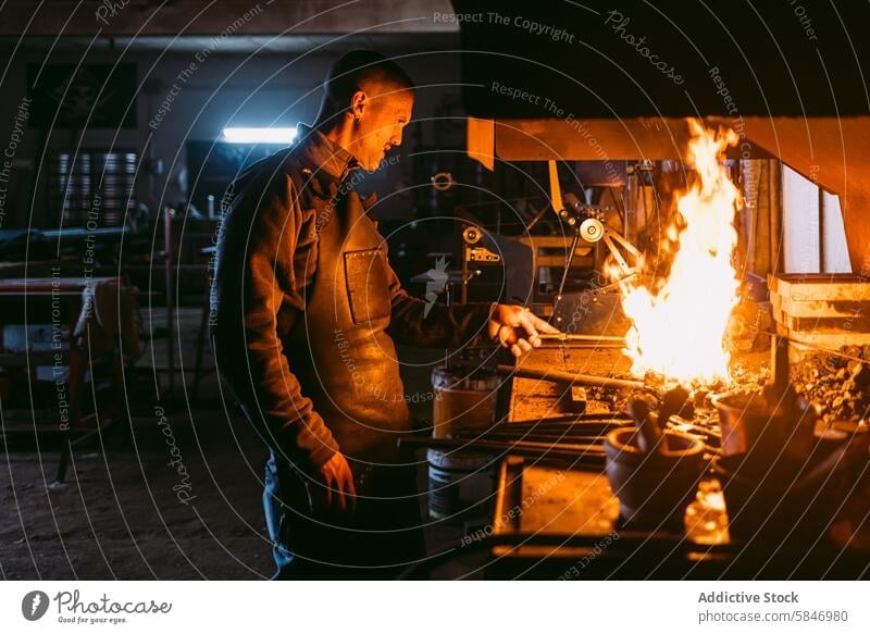 Blacksmith forging metal in traditional workshop blacksmith hot forge craftsmanship male fire profession artisan industry iron anvil hammer manufacture labor