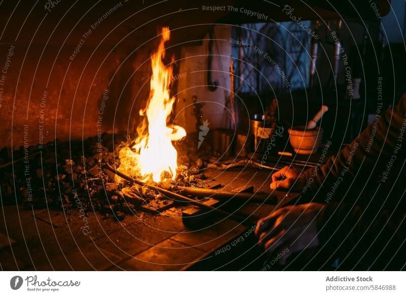 Artisan blacksmith working metal at fiery forge artisan workshop anvil shaping dark craftsmanship manual heat flame fire glow traditional tool skill profession