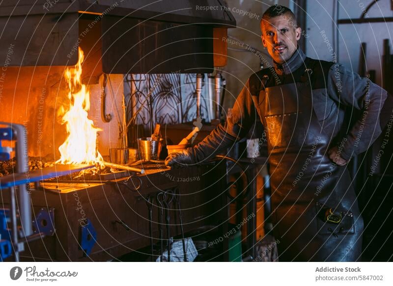 Blacksmith working at forge with fiery background blacksmith workshop craftsmanship skill male traditional profession industry manual labor artisan metalworking