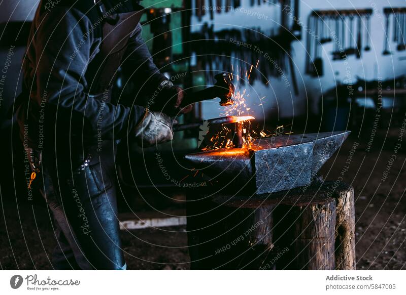 Blacksmith shaping metal on an anvil with sparks flying blacksmith forging iron workshop unrecognizable craft traditional hammer hot artisan skill manual labor