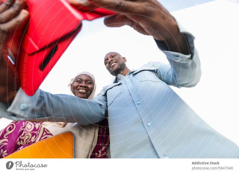 Joyful couple sharing gifts under a clear sky exchange happiness smiling man woman outdoor bright summer cheerful meeting colorful joy togetherness casual wear