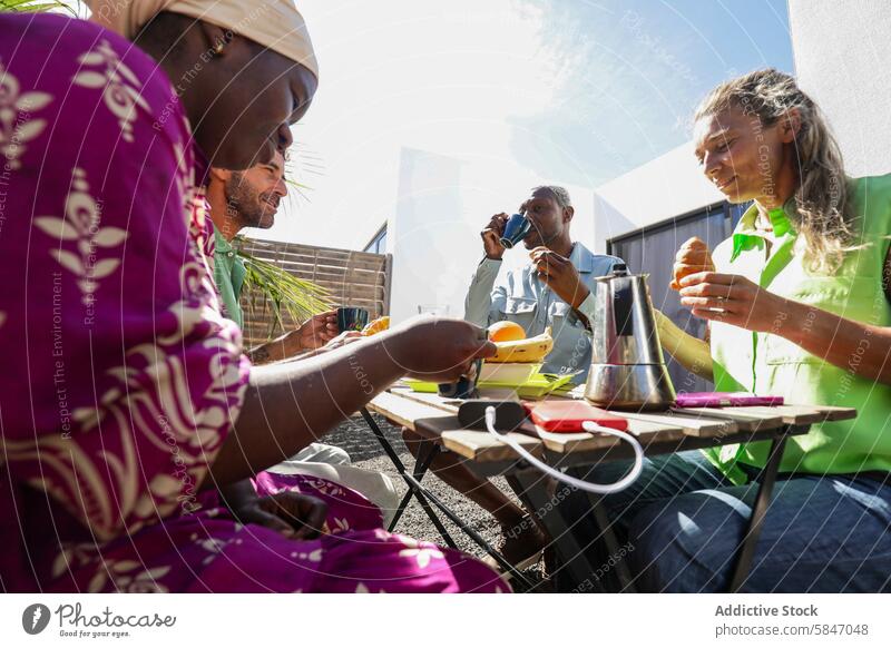 Summer Breakfast Meeting Outdoors with Diverse Friends summer breakfast meeting friends terrace sunny outdoors diverse group eating drinking coffee banana