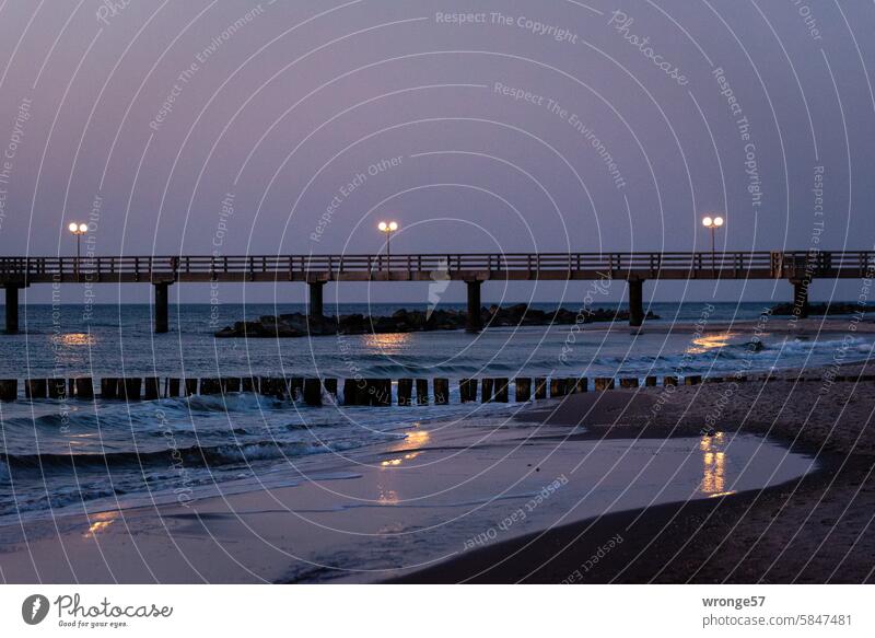 The lights of the Wustrow pier are reflected in the waters of the Baltic Sea Fischland Sea bridge clearer lamps reflection reflections Evening Dusk Water Ocean