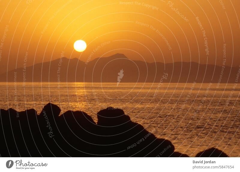 Orange-golden sunset over mountains on the Mediterranean Sunset Mediterranean sea the Aegean silent Peaceful