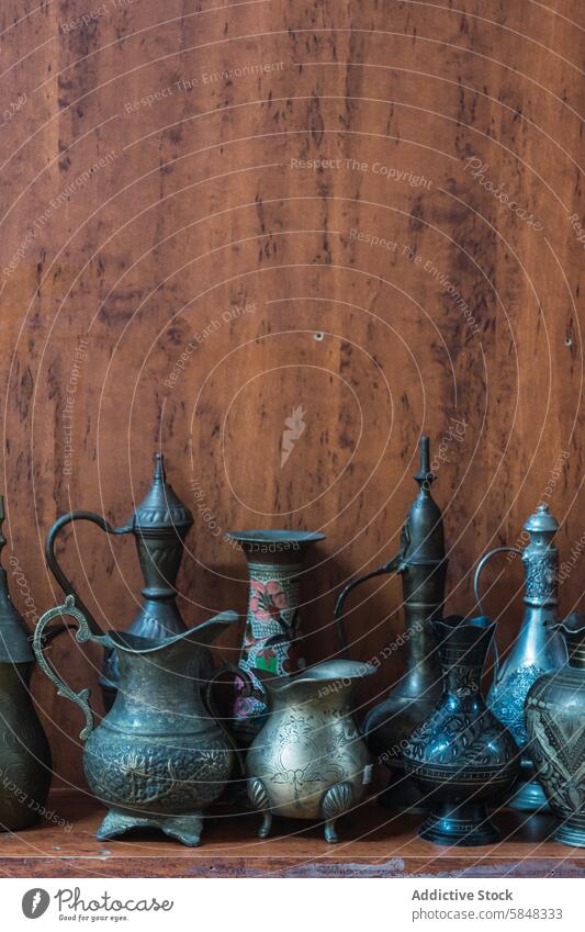 Traditional Omani metalwork on a wooden background omani craftsmanship jug vase traditional rustic ornate collection display art culture travel souvenir