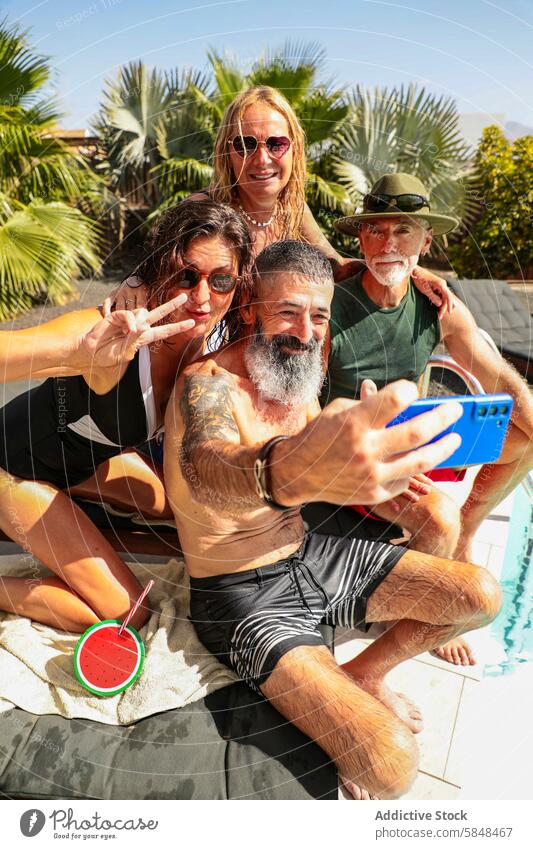 Joyful senior friends taking a selfie by the pool summer tropical cheerful sunny day group capture moment vibrant vibe tree background outdoor leisure fun