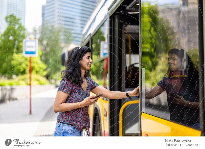 Young woman entering a city bus Indian real people fun summer enjoying street travel outdoors urban adult young adult attractive authentic beautiful cheerful