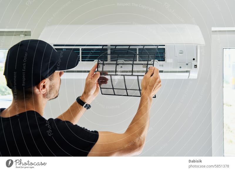 Air conditioner maintenance. Male technician repairing cooling system air conditioner service repairman temperature climate living room checking installation