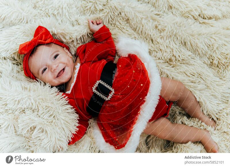 Baby's first Christmas in a festive outfit baby christmas bow blanket red child infant smile newborn holiday season cute adorable celebration december winter