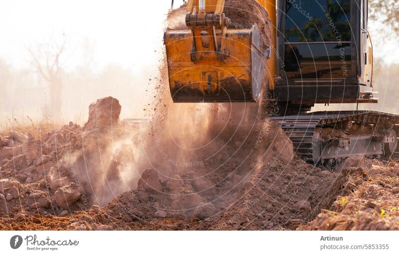 Close-up of excavator at construction site. Backhoe digging soil for earthwork and construction business. Excavating machine at work. Heavy machinery for earth moving and construction site development