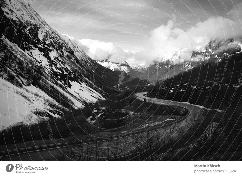 Norwegian landscape. The road leads through a mountain gorge that descends, glacier black and white nature panorama tourism travel Norway Gairanger country