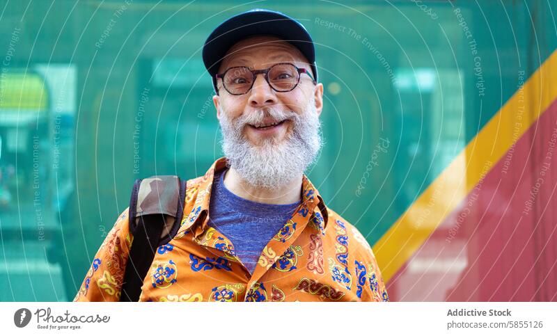 Senior man smiling in vibrant casual wear senior colorful shirt glasses stylish beard modern lifestyle joy happy remote work adaptable fashion trend freelance