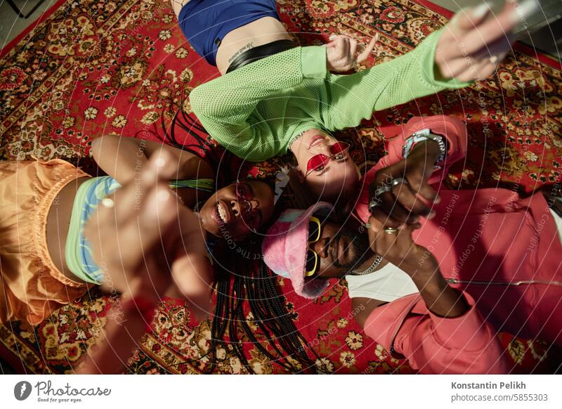 Young People Lying on Carpet in Circle lay floor carpet group people friend Black man woman girl hip-hop sunglasses look at camera influencer performer trend