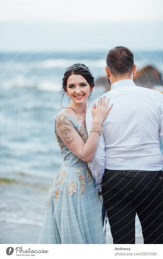 same couple with a bride in a blue dress walk adult beach beautiful beauty coast color concept female freedom girl groom hands happiness happy holding landscape