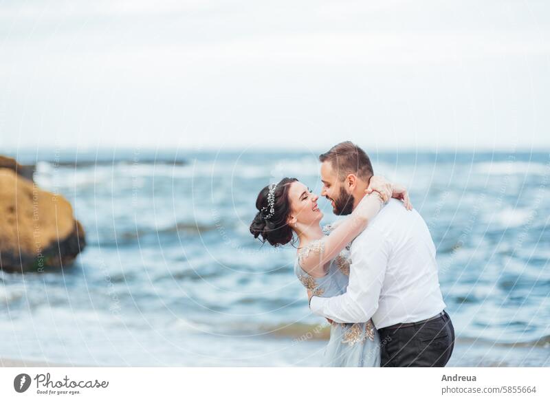 same couple with a bride in a blue dress walk adult beach beautiful beauty coast color concept female freedom girl groom hands happiness happy holding landscape