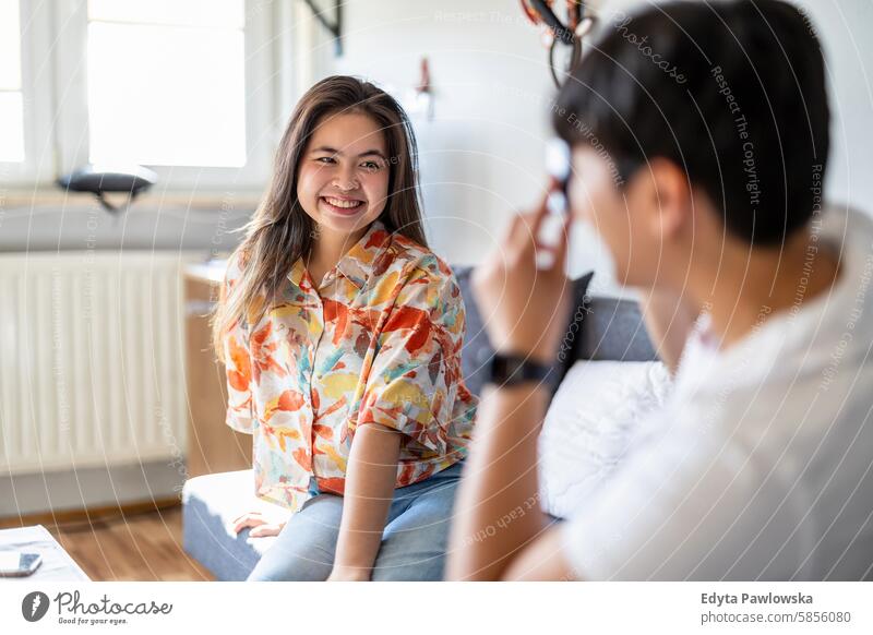 Young man photographing his girlfriend at home asian real people fun enjoying young adult authentic cheerful confident female happy millennials natural portrait