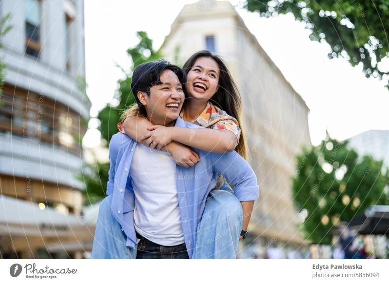 Happy young couple on city street asian real people fun enjoying young adult authentic cheerful confident female happy millennials natural portrait positive