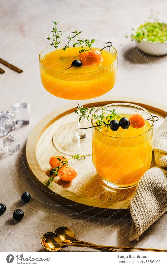 Summer drinks in two glasses on a wooden serving tray. Refreshing drink. Beverage Cold drink Orange Juice drinking glass Ready to serve Colour photo Lemonade