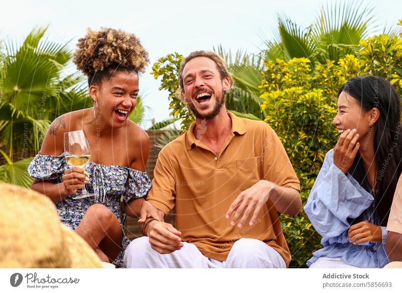 Diverse friends laughing and enjoying a rooftop party laughter drink conversation leisure caucasian african american woman smile engagement happiness outdoor