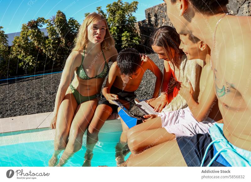 Triplets and Siblings Sharing a Tablet by the Pool pool tablet triplets siblings sunny day swimming family bonding technology leisure outdoor summer girl