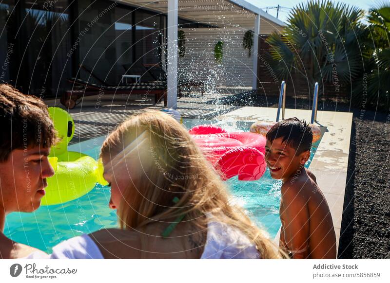 Family fun with siblings in swimming pool family girl boys looking at each other enjoyment water splash sunny outdoor summer leisure poolside relaxation