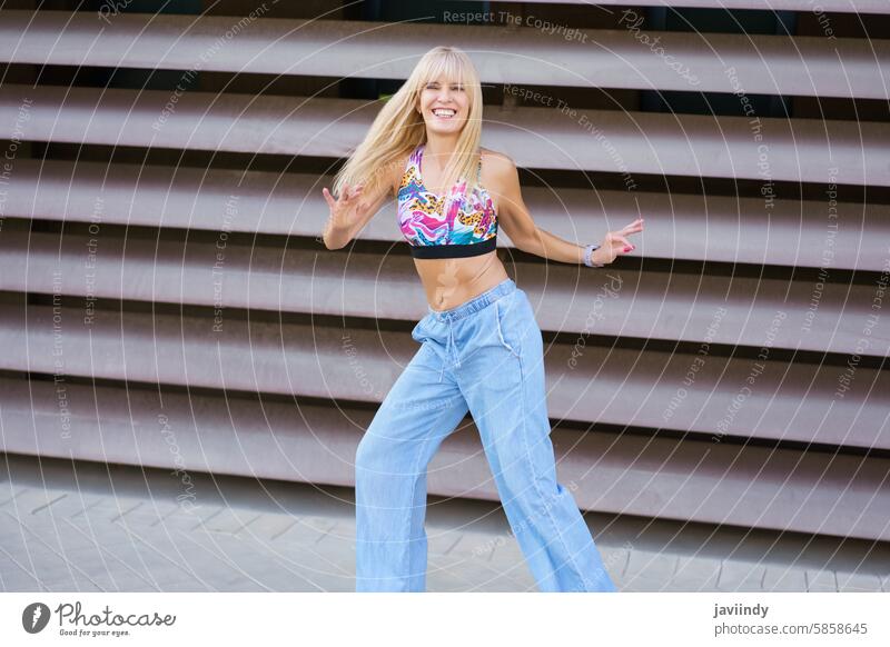 Blonde woman dancing in the street caucasian young dance joyful energetic vibrant blissful radiant carefree exuberant spirited lively jubilant sunny cheerful