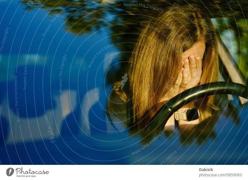 Woman is seated inside car with her head resting on steering wheel woman depression driving emotional bored driver sadness mental health problem daytime female