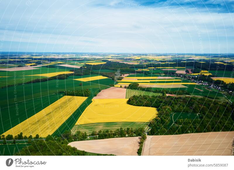 Aerial view of landscape with blooming rapeseed on agricultural fields crops rural farmland colors green yellow contrasting variety farming plantation nature