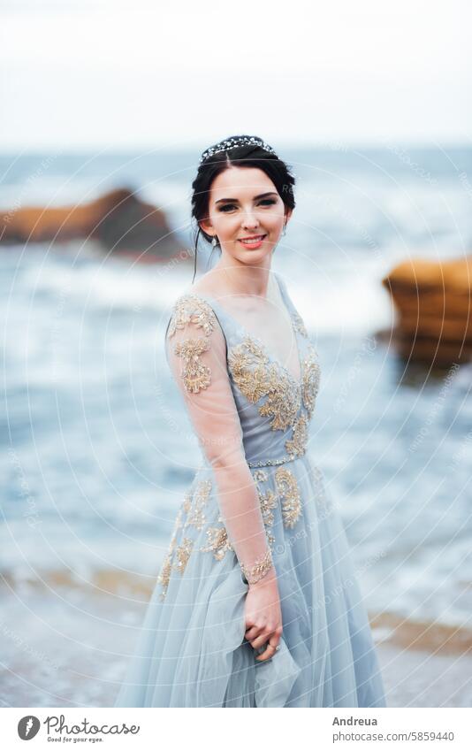 bride in a blue light dress walking along the ocean adult beach beautiful beauty coast color concept couple female freedom girl groom hands happiness happy