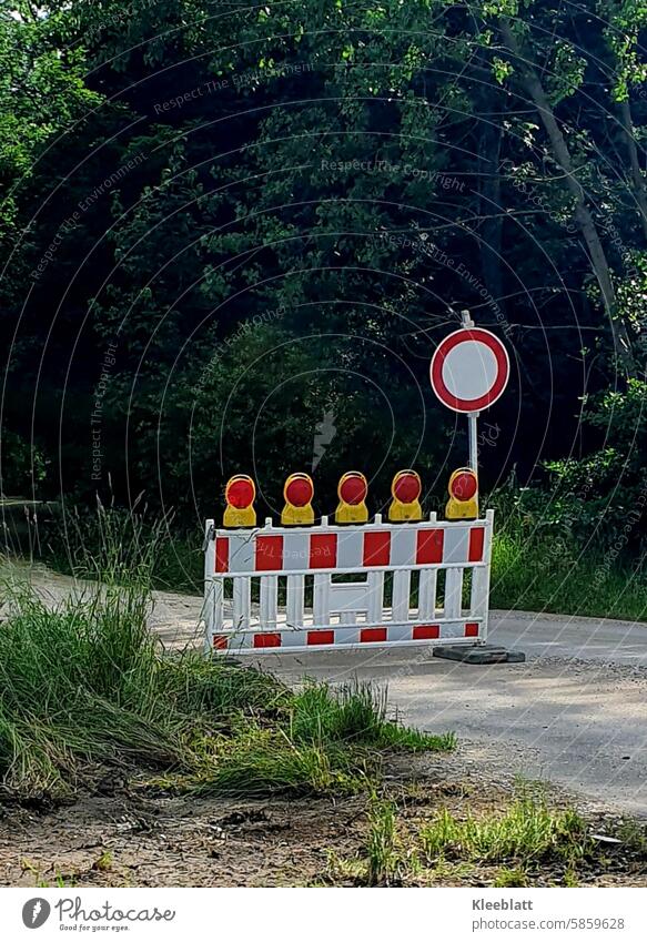 Access road closed - no way through - barrier fence with fluorescent lamps access road Barred no escape Protective Grating Illuminated lamps Signs and labeling