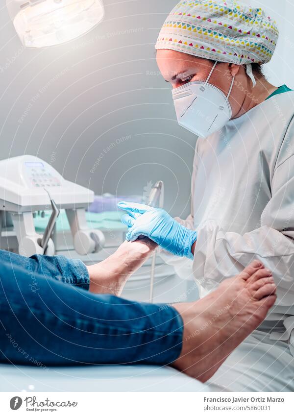Female podiatrist doing chiropody in her podiatry clinic. Selective focus woman nail callus patient pedicure health foot doctor care medicine clean hygiene toe