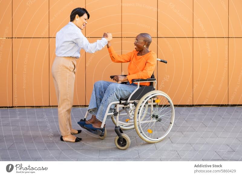 Professional meeting between a woman in a wheelchair and her colleague business inclusion diversity professional engagement outdoor smile interaction workforce