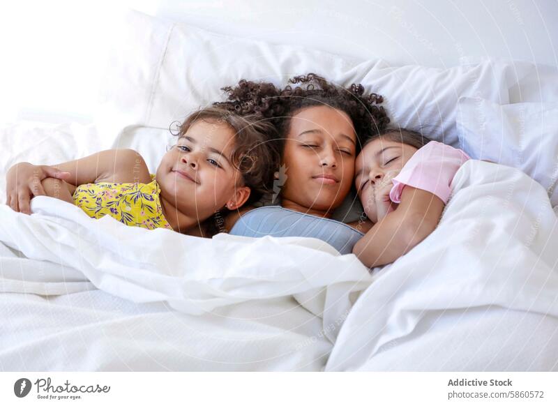 Multiethnic siblings snuggle up in bed after waking family morning multiethnic child cozy wake up love tranquil moment bedroom comfort sleep cuddle bond