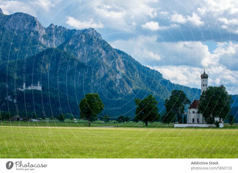 Saint Coleman Church with lush alpine backdrop in Fussen, Germany saint coleman church fussen germany landscape alps mountain architecture field green nature