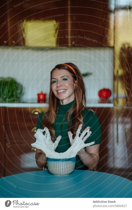 Smiling woman playing with cake batter in vintage kitchen 1950s dough smiling playful caucasian retro red hair fun cooking baking happy housewife green shirt