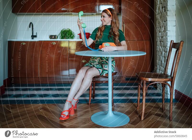 Retro housewife with phone in a vintage kitchen setting woman retro 1950s telephone amused sitting stylish throwback table wooden furniture classic outfit