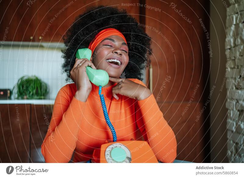 Joyful 1950s-inspired housewife chatting on vintage phone joyful kitchen orange style black african american looking away fashion nostalgia interior