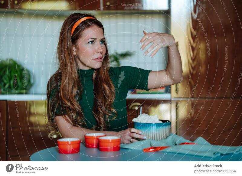 Comical 50s housewife perplexed by pasta dough in her hand woman 1950s kitchen cooking vintage retro confusion costume 50's comical green redhead looking away