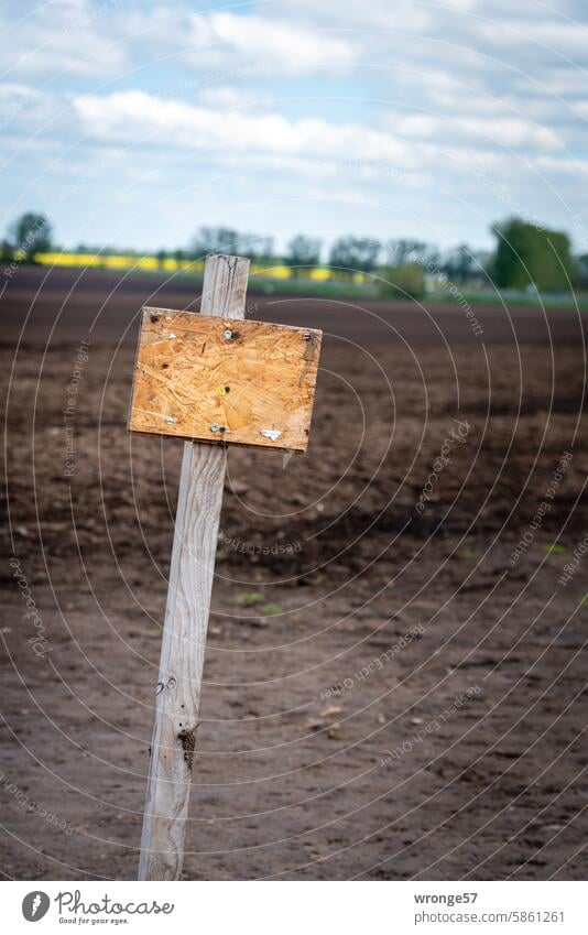 Empty wooden board in front of a plowed field wooden panel Signs and labeling Signage Exterior shot Colour photo Arable land Field unsolicited Deserted sign