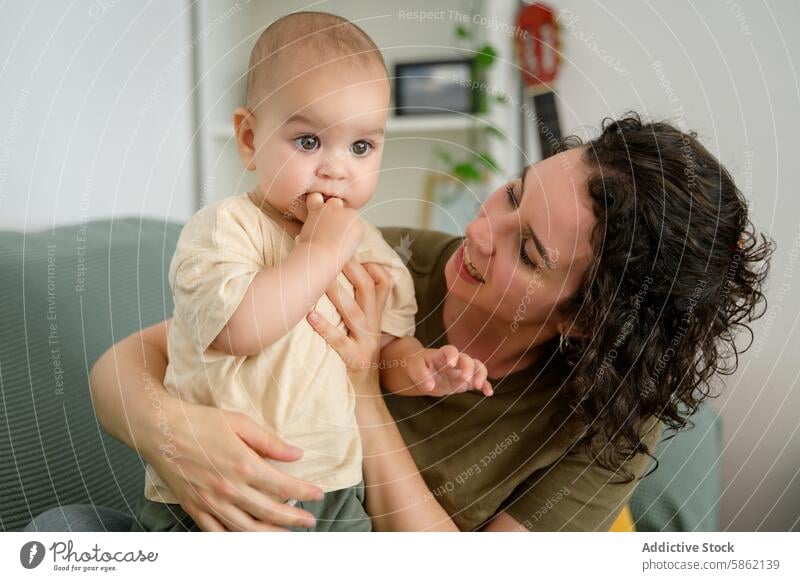 Cheerful mother playing with baby at home indoor playful affectionate love bonding family caucasian child woman joy happiness adult care caring parent parenting