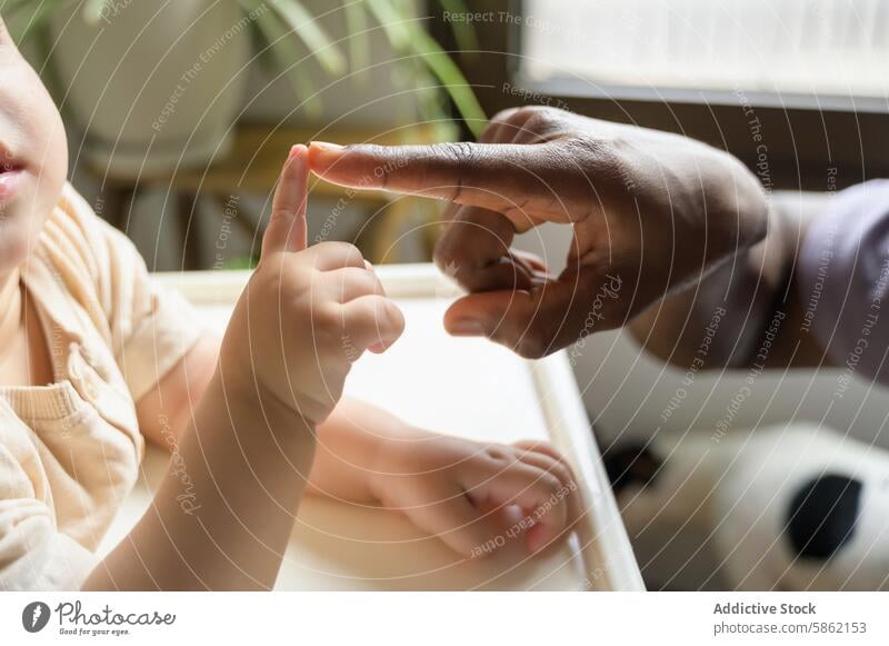 Teaching moment between African American man and Caucasian child african american toddler learning teaching finger counting indoor activity education engagement