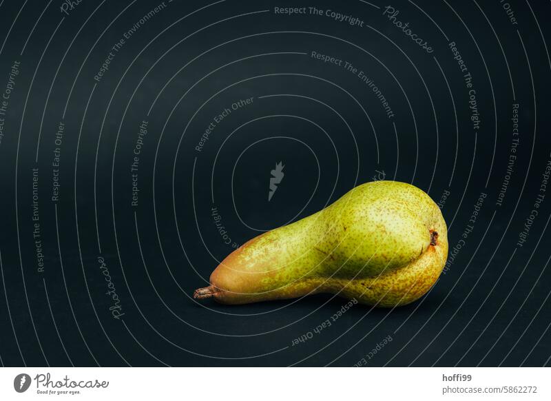 the pear Abate Fetel in the spotlight Pear Close-up black background Fruit Fresh cute Delicious Green Mature Vegetarian diet Healthy Nutrition Organic Diet