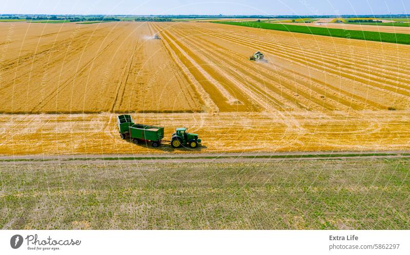 Above view on combine, tractor waits for transshipment as harvester harvest wheat Aerial Agriculture Cereal Combine Country Crop Cultivation Cut Dry Dust Dusty