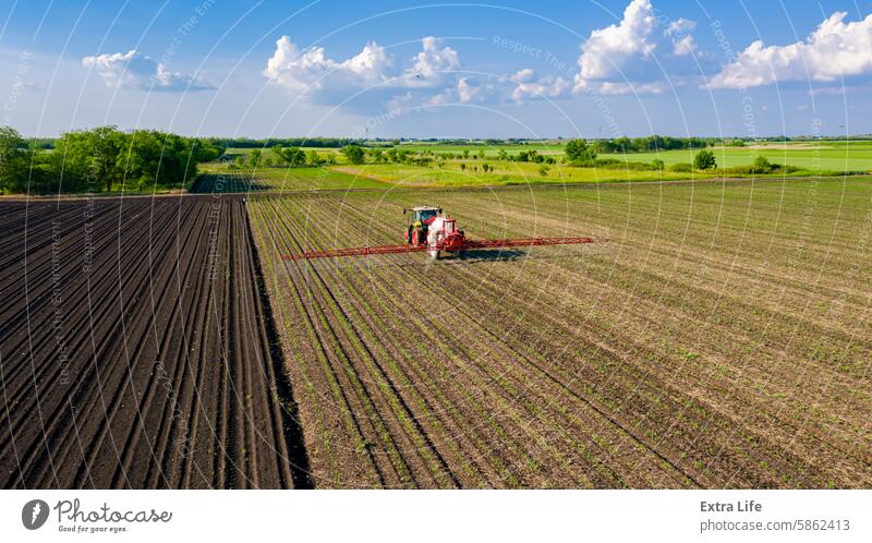 Aerial view on tractor as spraying field with sprayer, herbicide and pesticide Above Aerosol Agricultural Agriculture Arable Biochemical Biohazard Care Cereal