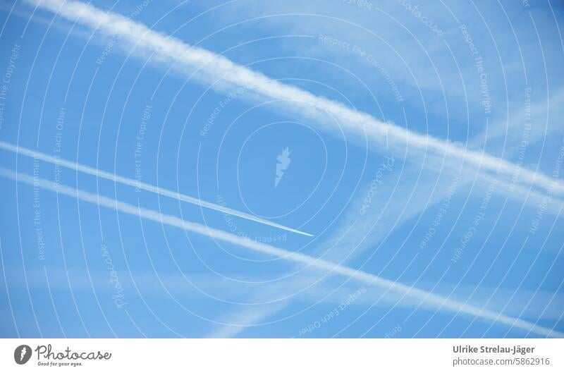 Heavenly weaving patterns | Condensation trails in the light blue sky crossed Tracks Fly-by fly by air traffic Aviation Beautiful weather lines Airlines