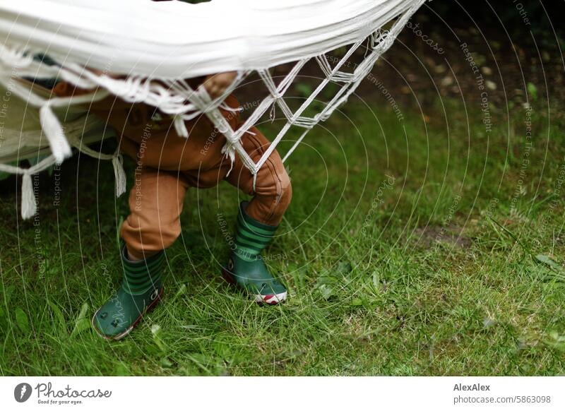 [HH Schregatour24] A little boy in funny rubber boots gets tangled up in a hammock and can't get out of it Boy (child) Child Garden Hammock Captured Adversity
