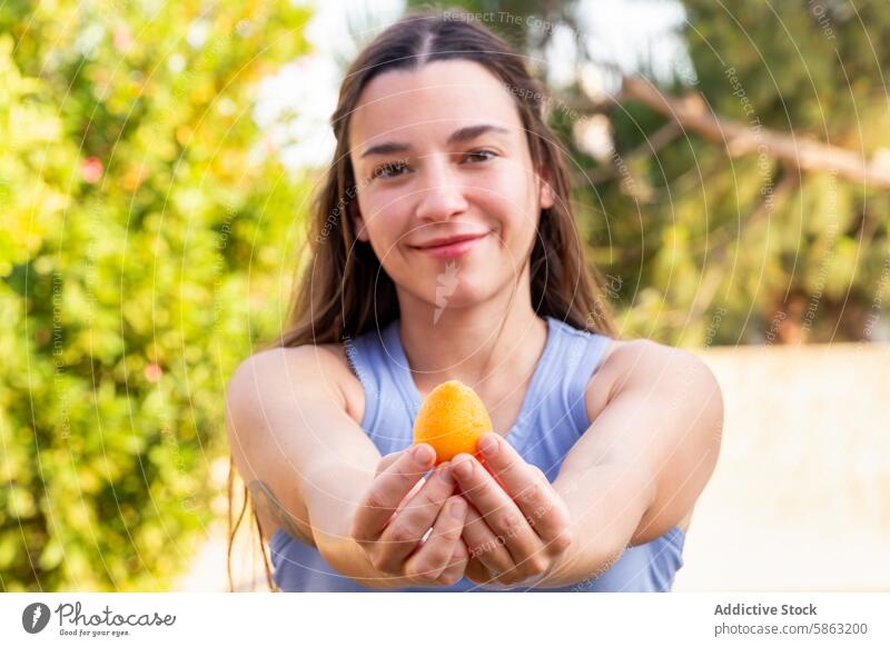 Woman Proudly Holding Freshly Picked Fruit in Garden woman garden fruit picking fresh outdoor horticulture gardening portrait care nature activity summer