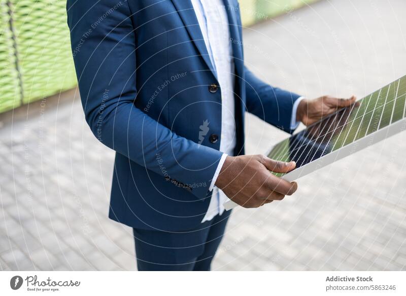 Black businessman examining solar panel outdoors black renewable energy innovation suit blue formal holding sustainable energy solar power technology